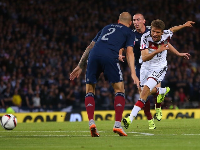 Germany's midfielder Thomas Muller (R) shoots to score the opening goal of the Euro 2016 qualifying group D football match between Scotland and Germany at Hampden Park in Glasgow on September 7, 2015
