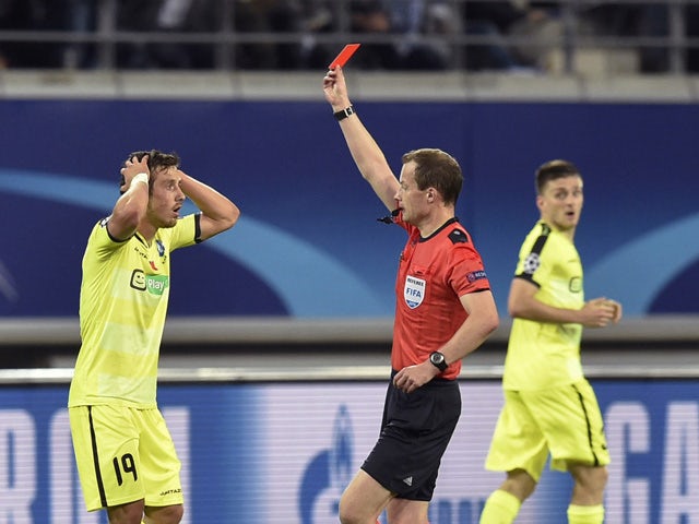 Gent's midfielder Brecht Dejaegere receives a red card by referee William Collum during the UEFA Champions League football match between Kaa Gent and Olympique Lyonnais (OL) at Ghelamco stadium in Ghent, on September 16, 2015