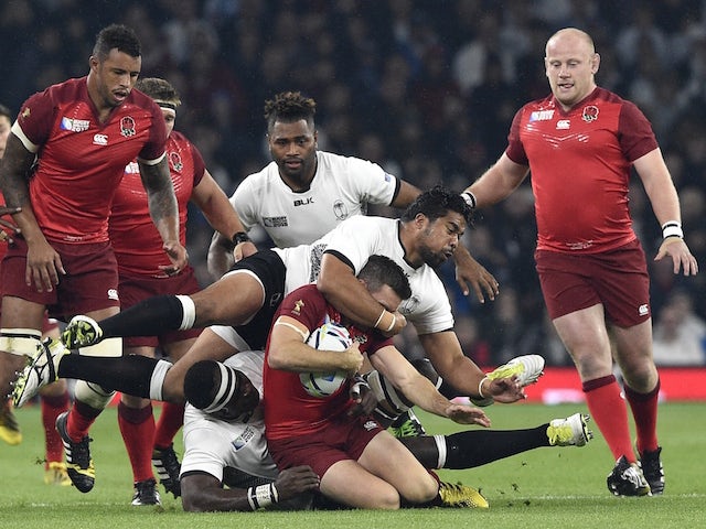 England's fly-half George Ford (C) is tackled during a Pool A match of the 2015 Rugby World Cup between England and Fiji at Twickenham stadium in south west London on September 18, 2015.