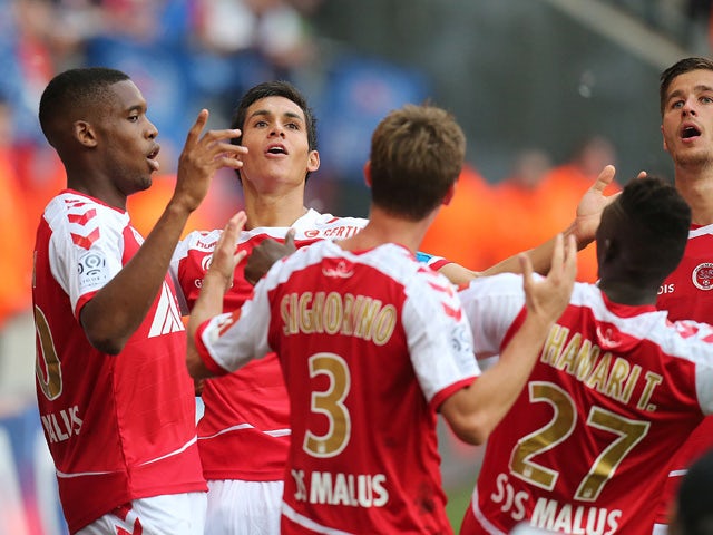 Reims' defender Jordan Siebatcheu is congratulated by his teammates on scoring during the French Ligue 1 football match between Reims and Paris Saint-Germain on September 19, 2015