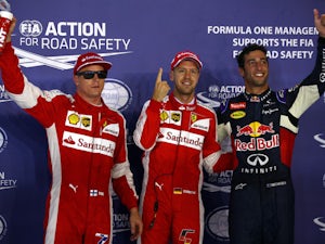 Sebastian Vettel of Germany and Ferrari celebrates in Parc Ferme next to Daniel Ricciardo of Australia and Infiniti Red Bull Racing and Kimi Raikkonen of Finland and Ferrari after claiming pole position during qualifying for the Formula One Grand Prix of 