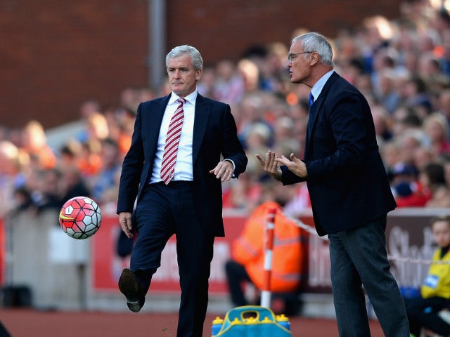 Mark Hughes manager of Stoke City kicks the ball while Claudio Ranieri Manager of Leicester City instructs his players during the Barclays Premier League match between Stoke City and Leicester City at Britannia Stadium on September 19, 2015 in Stoke on Tr