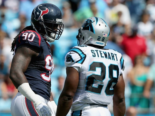 Jonathan Stewart #28 of the Carolina Panthers exchanges words with Jadeveon Clowney #90 of the Houston Texans in the first quarter during their game at Bank of America Stadium on September 20, 2015 in Charlotte, North Carolina.