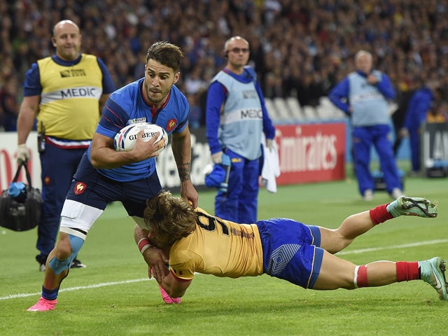 France's wing Sofiane Guitoune (L) is tackled by Romania's scrum half Florin Surugiu as he runs to score a try during a Pool D match of the 2015 Rugby World Cup between France and Romania at the Olympic stadium, east London, on September 23, 2015