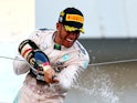 Lewis Hamilton of Great Britain and Mercedes GP celebrates with the trophy on the podium after winning the Formula One Grand Prix of Japan at Suzuka Circuit on September 27, 2015