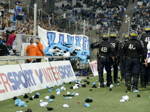 In this picture taken on September 20, 2015 riot police patrol around the touchline after crowd trouble during the French L1 football match Marseille (OM) vs Lyon (OL) at the Velodrome Stadium in Marseille, southern France. Play was resumed after an inter