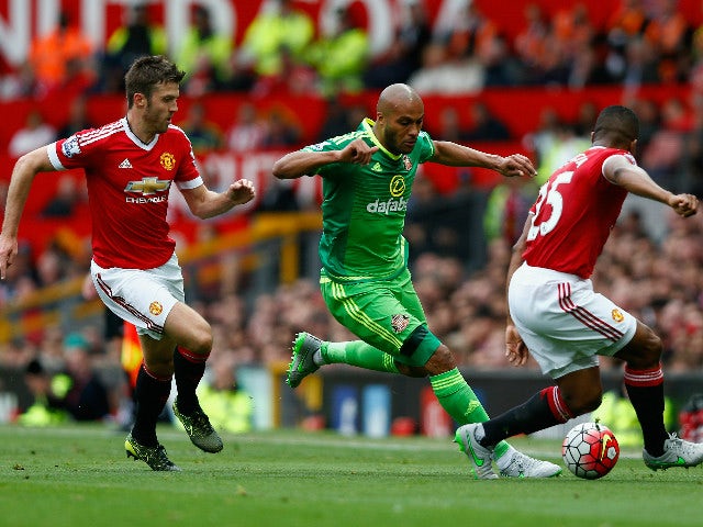 Younes Kaboul (C) of Sunderland competes against Michael Carrick (L) and Antonio Valencia (R) of Manchester United during the Barclays Premier League match between Manchester United and Sunderland at Old Trafford on September 26, 2015 in Manchester, Unite