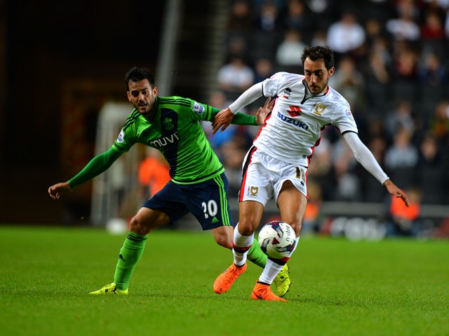 Sergio Aguza of MK Dons is tackled by Juanmi of Southampton during the Capital One Cup third round match between MK Dons and Southampton at Stadium mk on September 23, 2015