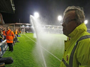 A safety steward tries to stop the pitch watering system as it comes on during the English League Cup third round football match between Walsall and Chelsea at The Banks's Stadium in Walsall, central England on September 23, 2015
