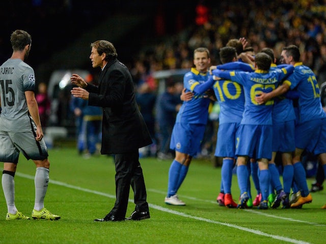 Roma's French coach Rudi Garcia (C) gives instructions to his player as BATE's players celebrate a goal during the UEFA Champions League group E football match between FC BATE Borisov and AS Roma at the Borisov-Arena in Borisov outside Minsk on September 
