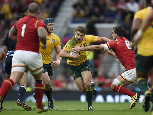 Australia's wing Drew Mitchell (C) runs past Wales' flanker and captain Sam Warburton (R) during a Pool A match of the 2015 Rugby World Cup between Wales and Australia at Twickenham Stadium, south west London, on October 10, 2015