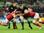 New Zealand's flanker Sam Cane (C) is tackled by Tonga's lock Tukulua Lokotui during a Pool C match of the 2015 Rugby World Cup between New Zealand and Tonga at St James' Park in Newcastle-upon-Tyne, northeast England, on October 9, 2015