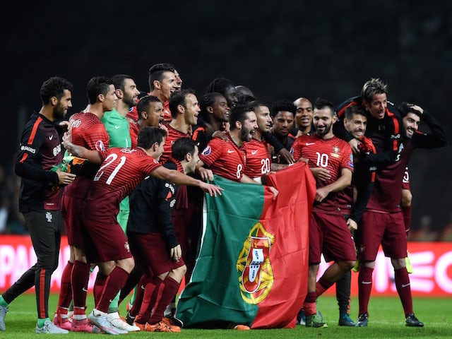 Portugal's players celebrate as they pose with a Portuguese flag at the end of the Euro 2016 qualifying football match Portugal vs Denmark at the Municipal stadium in Braga on October 8, 2015.