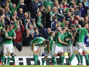 Northern Ireland's midfielder Steven Davis (L) celebrates with teammates after scoring the opening goal during the UEFA Euro 2016 qualifying Group F football match between Northern Ireland and Greece at Windsor Park in Belfast, Northern Ireland, on Octobe