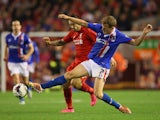 Tom Miller of Carlisle United stretches for the ball ahead of Danny Ings of Liverpool during the Capital One Cup Third Round match between Liverpool and Carlisle United at Anfield on September 23, 2015 in Liverpool, England.