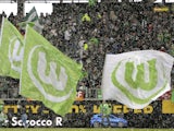 Snow falls as Wolfsburg flags are waved by fans next to the pitch ahead of the German first division Bundesliga football VfL Wolfsburg vs Borussia Dortmund in the northern German city of Wolfsburg on April 7, 2012