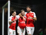 Aaron Ramsey of Arsenal (C) celebrates with Hector Bellerin (L) and Olivier Giroud (R) as he scores their third goal during the Barclays Premier League match between Watford and Arsenal at Vicarage Road on October 17, 2015 in Watford, England. 