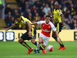 Alexis Sanchez of Arsenal and Troy Deeney of Watford compete for the ball during the Barclays Premier League match between Watford and Arsenal at Vicarage Road on October 17, 2015 in Watford, England. 