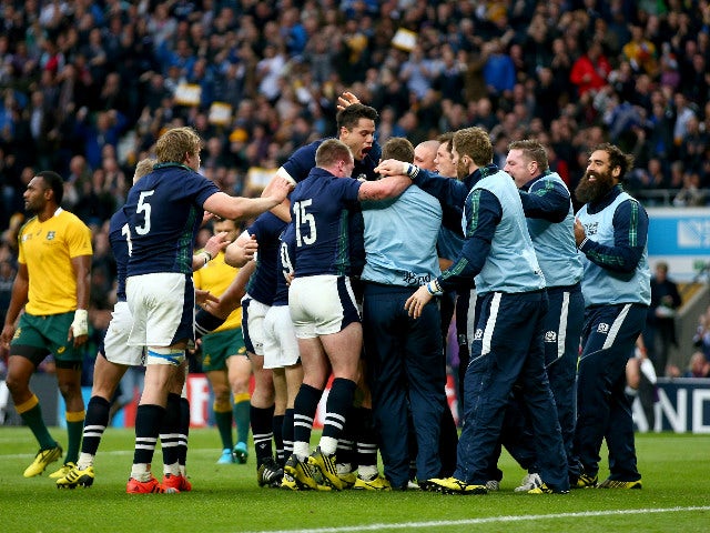 Scotland players and substitutes mob try scorer Peter Horne of Scotland during the 2015 Rugby World Cup Quarter Final match between Australia and Scotland at Twickenham Stadium on October 18, 2015 in London, United Kingdom. 