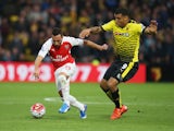 Santi Cazorla of Arsenal and Troy Deeney of Watford compete for the ball during the Barclays Premier League match between Watford and Arsenal at Vicarage Road on October 17, 2015 in Watford, England.