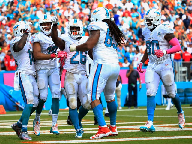 Lamar Miller #26 of the Miami Dolphins celebrates his touchdown with his teammates in the second quarter against the Houston Texans at Sun Life Stadium on October 25, 2015
