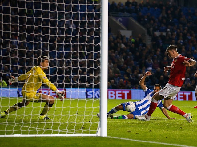 Sam Baldock of Brighton equalises despite the efforts of goalkeeper Frank Fielding and Aden Flint of Bristol City during the Sky Bet Championship match between Brighton & Hove Albion and Bristol City at Amex Stadium on October 20, 2015 in Brighton, Englan