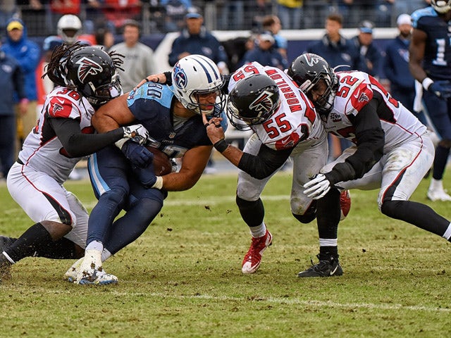 Anthony Fasano #80 of the Tennessee Titans is gang tackled by Kemal Ishmael #36, Paul Worrilow #55, and Justin Durant #52 of the Atlanta Falcons during the second half at Nissan Stadium on October 25, 2015