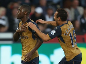 Joel Campbell (L) of Arsenal celebrates scoring his team's third goal with his team mate Santi Cazorla (R) during the Barclays Premier League match between Swansea City and Arsenal at Liberty Stadium on October 31, 2015