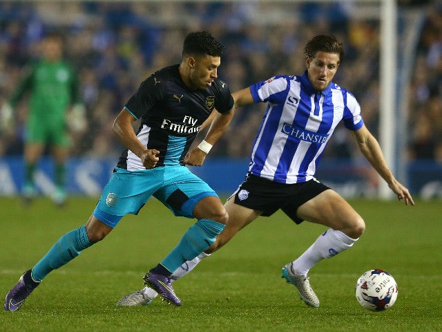 Alex Oxlade-Chamberlain of Arsenal and Sam Hutchinson of Sheffield Wednesday compete for the ball during the Capital One Cup fourth round match between Sheffield Wednesday and Arsenal at Hillsborough Stadium on October 27, 2015 in Sheffield, England.