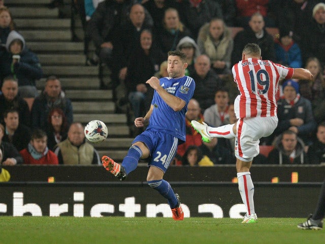 Stoke City's English-born Irish striker Jonathan Walters (R) shoots past Chelsea's English defender Gary Cahill (C) to score his team's first goal during the English League Cup fourth round football match between Stoke City and Chelsea at the Britannia St
