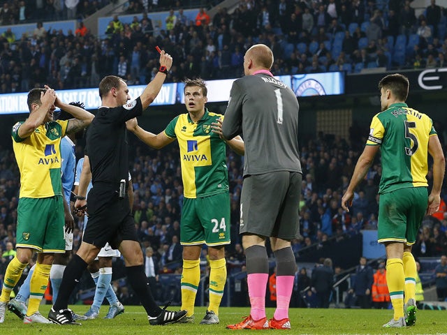 Referee Robert Madley shows Norwich City's Scottish defender Russell Martin (R) a red card during the English Premier League football match between Manchester City and Norwich City at The Etihad Stadium in Manchester, north west England on October 31, 201