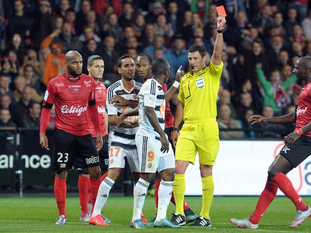 French referee Nicolas Rainville (R) shows a red card to Lorient's Cameroonian forward Waris Majeed during the French L1 match between Guingamp and Lorient, on October 31, 2015 at the Roudourou stadium in Guingamp, western of France.