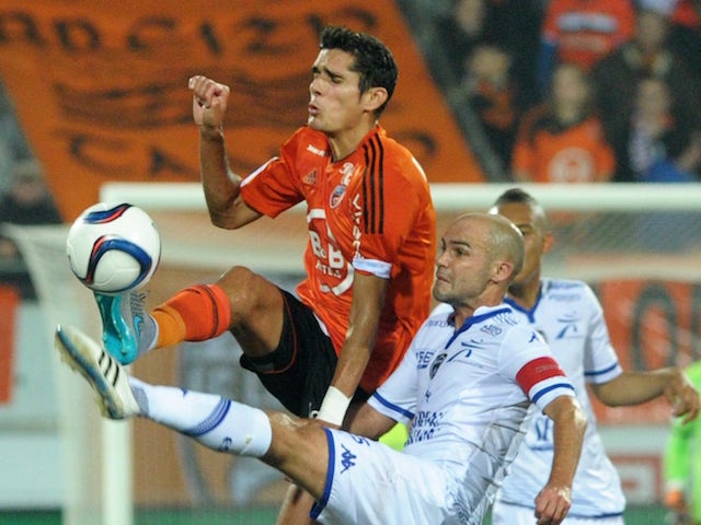 Lorient's French defender Francois Belugou (L) vies with Troyes' French midfielder Benjamin Nivet during the French Ligue 1 match Lorient versus Troyes on November 7, 2015 at the Yves Allainmat stadium in Lorient, western France.