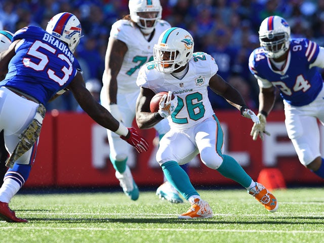 Lamar Miller #26 of the Miami Dolphins runs the ball as Nigel Bradham #53 of the Buffalo Bills defends during the first half at Ralph Wilson Stadium on November 8, 2015