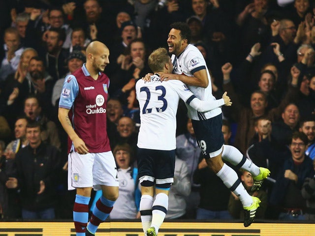 Alan Hutton of Aston Villa looks dejected as Mousa Dembele of Tottenham Hotspur (19) celebrates with Christian Eriksen after scoring their frst goal during the Barclays Premier League match between Tottenham Hotspur and Aston Villa at White Hart Lane on N