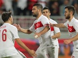 Turkey's captain Arda Turan (C) is congratulated by teammates after his goal during their friendly football match against Qatar in the capital Doha on November 13, 2015.