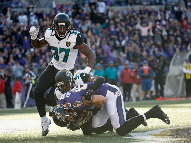 Crockett Gillmore #80 of the Baltimore Ravens catches a first half touchdown pass in front of Johnathan Cyprien #37 and Thurston Armbrister #57 of the Jacksonville Jaguars at M&T Bank Stadium on November 15, 2015