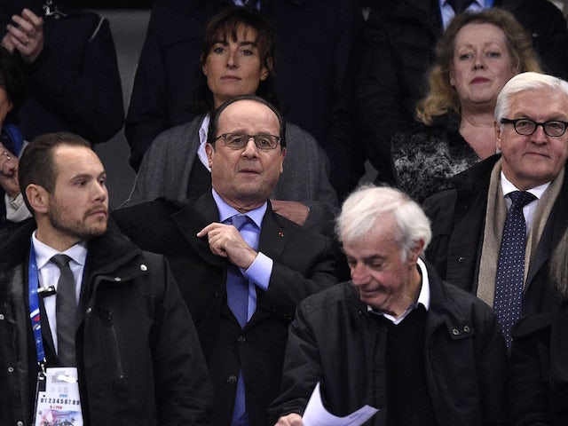 French President Francois Hollande (C) and Germany's Foreign Minister Frank-Walter Steinmeier (R) attend a friendly international football match between France and Germany ahead of the Euro 2016, on November 13, 2015 at the Stade de France stadium in Sain