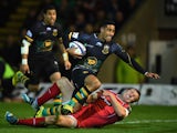 Ken Pisi of Northampton crashes over the tryline to score the opening try despite the tackle from Hadleigh Parkes of Scarlets during the European Rugby Champions Cup Pool 3 match between Northampton Saints and Scarlets at Franklin's Gardens on November 14