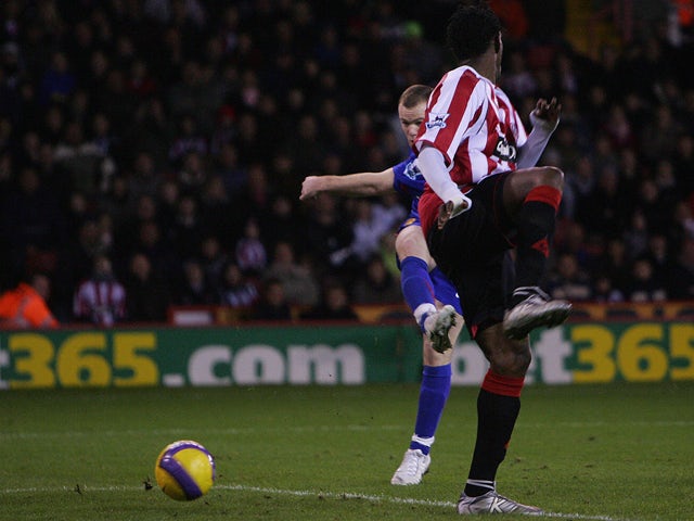 Manchester United's Wayne Rooney (L) beats Sheffield United's Claude Davis to score the second goal during their English Premiership football match at Bramall Lane, Sheffield, England, November 18 2006