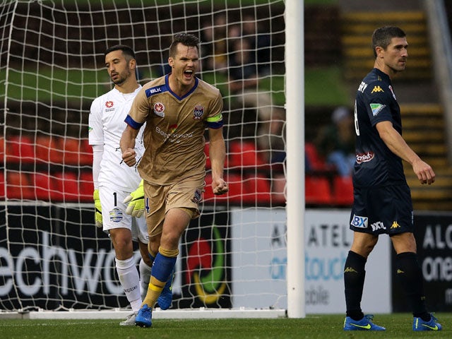 Nigel Boogaard of the Jets celebrates a goal by Milos Trifunovic with Paul Izzo and Nick Montgomery of the Mariners looking dejected in frame during the round six A-League match between the Newcastle Jets and the Central Coast Mariners at Hunter Stadium o
