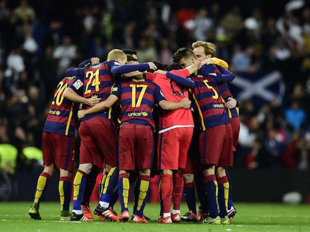 Barcelona's players celebrate during the Spanish league 'Clasico' football match Real Madrid CF vs FC Barcelona at the Santiago Bernabeu stadium in Madrid on November 21, 2015.