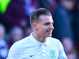 Jason Cummings of Hibernian is shown a yellow card by referee Steven McLean after celebrating scoring the opening goal with his team-mates in front of the Hearts fans in the first half during the Scottish Championship match between Heart of Midlothian F.C