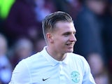 Jason Cummings of Hibernian is shown a yellow card by referee Steven McLean after celebrating scoring the opening goal with his team-mates in front of the Hearts fans in the first half during the Scottish Championship match between Heart of Midlothian F.C