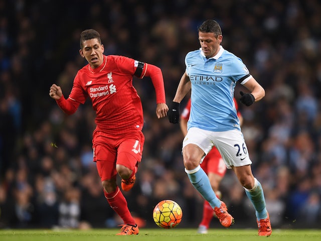 Martin Demichelis of Manchester City and Roberto Firmino of Liverpool compete for the ball during the Barclays Premier League match between Manchester City and Liverpool at Etihad Stadium on November 21, 2015 in Manchester, England. 