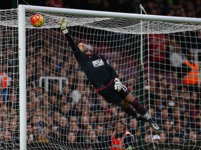 West Bromwich Albion's US-born Welsh goalkeeper Boaz Myhill dives but cannot reach the freekick from West Ham United's Argentinian striker Mauro Zarate (not pictured) as West Ham score the first goal of the English Premier League football match between We