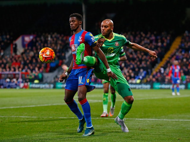 Wilfried Zaha of Crystal Palace is tackled by Younes Kaboul of Sunderland during the Barclays Premier League match between Crystal Palace and Sunderland at Selhurst Park on November 23, 2015