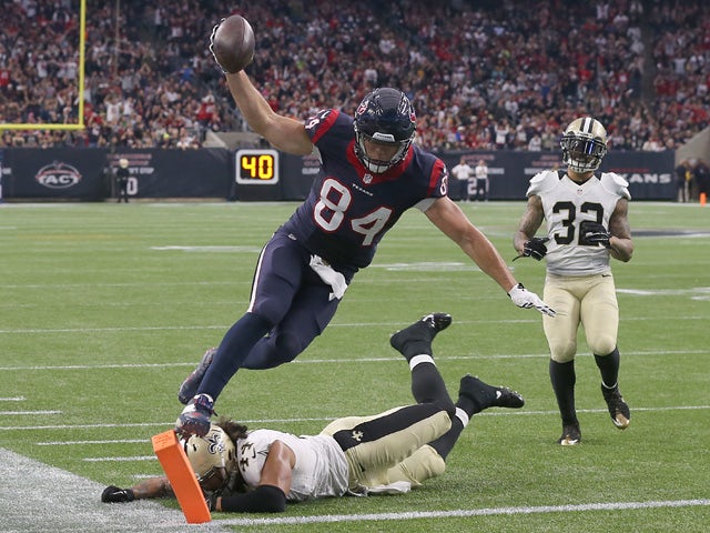 Ryan Griffin #84 of the Houston Texans jumps and lands on the pylon to score a touchdown while Vinnie Sunseri #43 of the New Orleans Saints defends on the play on November 29, 2015