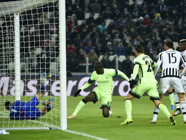 Juventus' goalkeeper from Italy Gianluigi Buffon (L) makes a save in front of Manchester City's Ivorian midfielder Yaya Toure (C) during the UEFA Champions League football match Juventus vs Manchester City on November 25, 2015