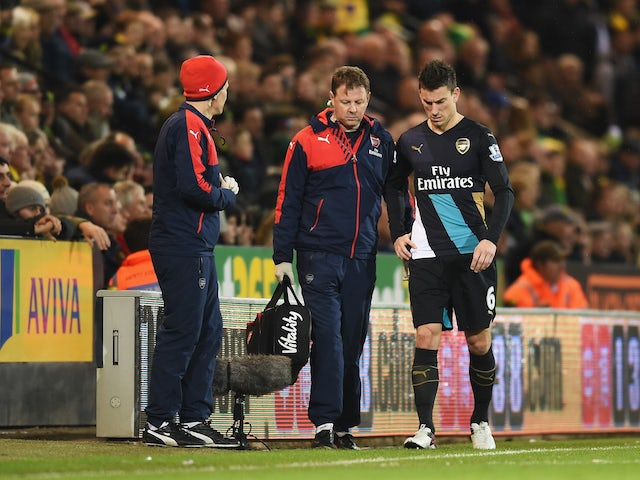 An injured Laurent Koscielny of Arsenal leaves the pitch during the Barclays Premier League match between Norwich City and Arsenal at Carrow Road on November 29, 2015 in Norwich, England.